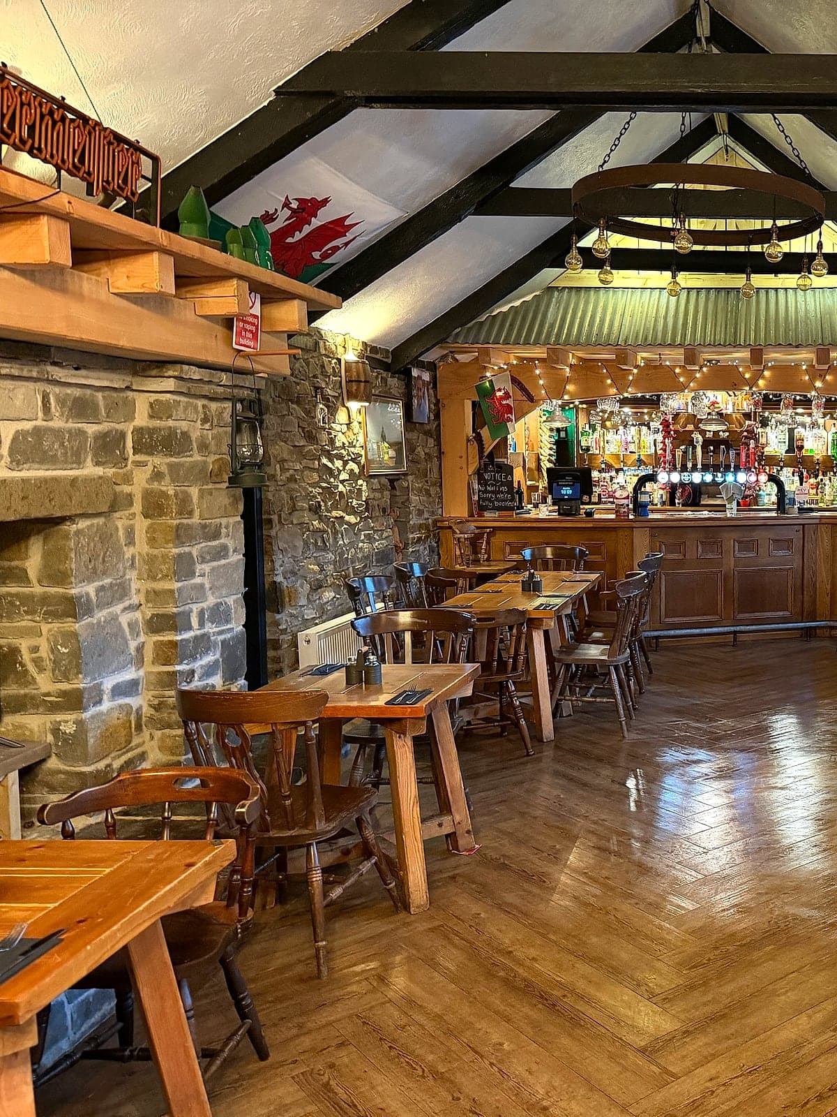 BB's Bar, the bottom bar at Jan'z, with oak beams, a stone fireplace and the bar at the far end