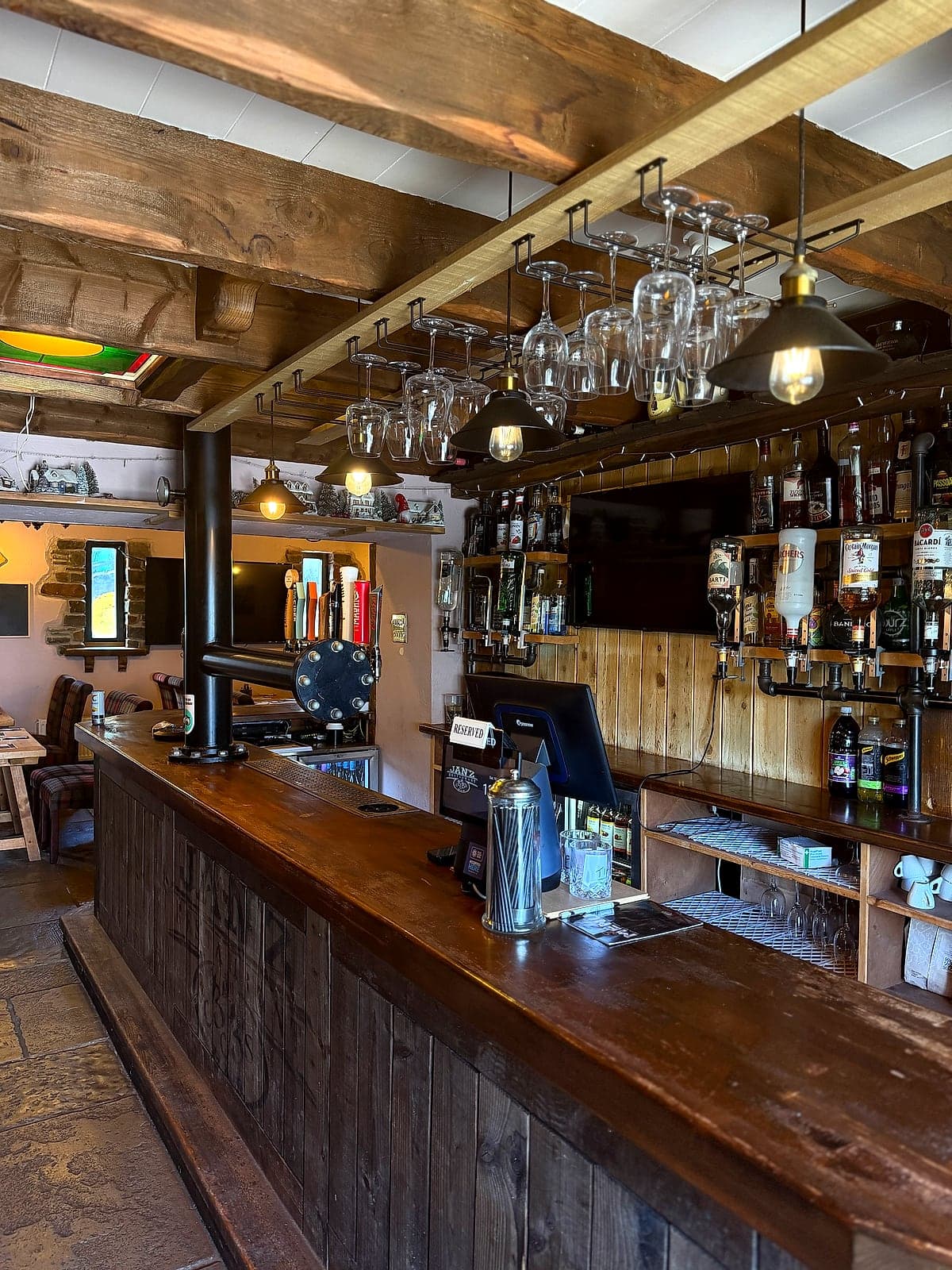 The restaurant bar at Jan'z, with glasses hanging over the bar and spirits on the shelves