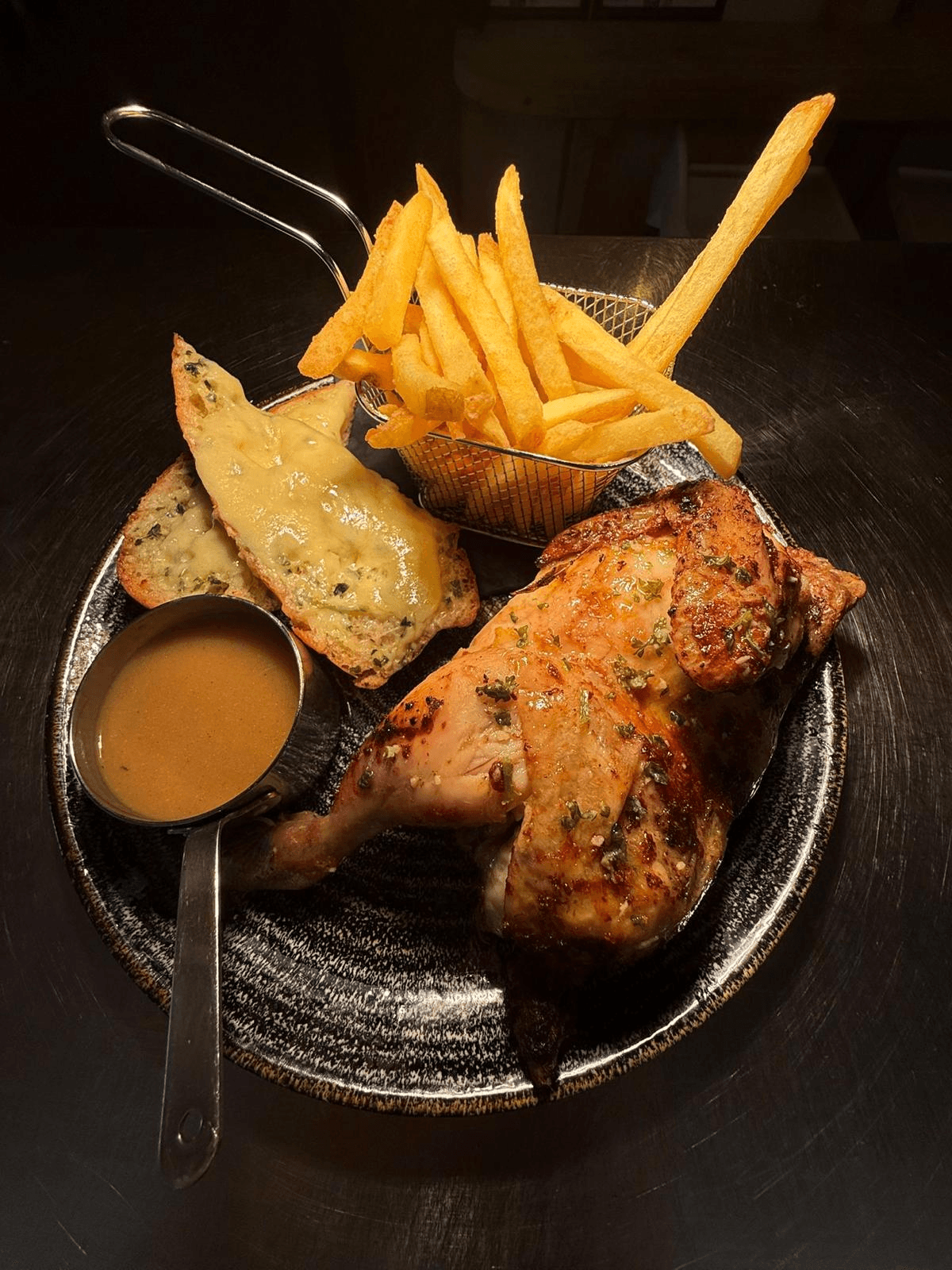 Rotisserie chicken served with chips, garlic bread and gravy at Jan'z
